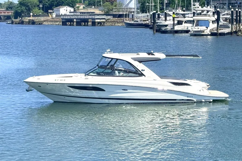 Slide: The Image of 2016 Sea Ray SLX 350 boat cruising on a calm waterfront near a marina. - 4