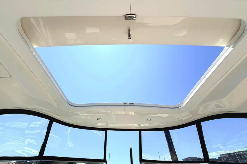 Slide: The Image of Sunroof view from a 2016 Sea Ray SLX 350 boat, showcasing clear blue sky. - 20