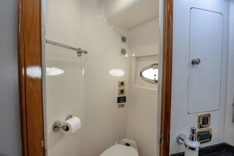 Slide: The Image of The image shows a boat bathroom with a toilet, towel rack, and porthole. - 19