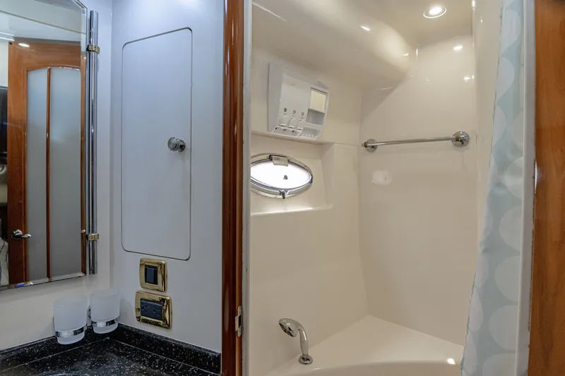 Slide: The Image of The image shows a sleek yacht bathroom with a shower, mirror, and porthole. - 20