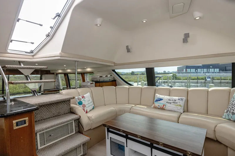 Slide: The Image of Interior of a 2002 Carver 530 Voyager Pilothouse with beige sofa and wooden table. - 10