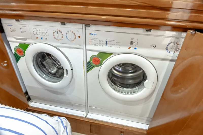 Slide: The Image of Washing machine and dryer set in a wooden enclosure on a boat. - 21