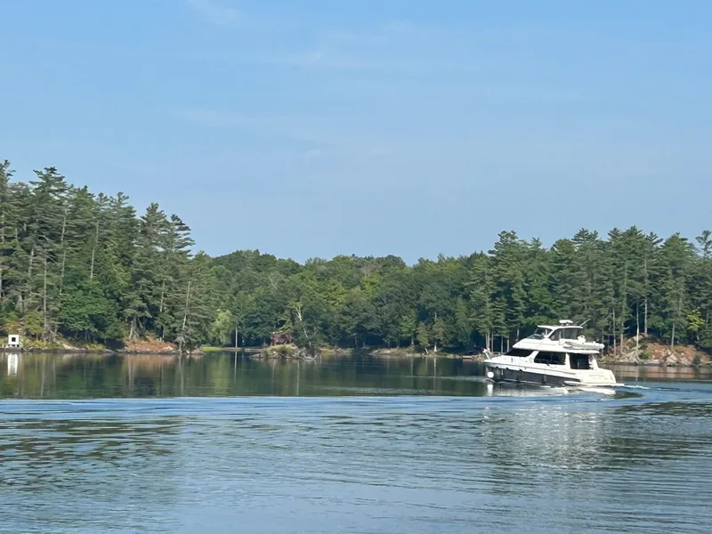 Slide: The Image of A 2002 Carver Voyager Pilothouse 530 cruising on a calm lake, surrounded by trees. - 5
