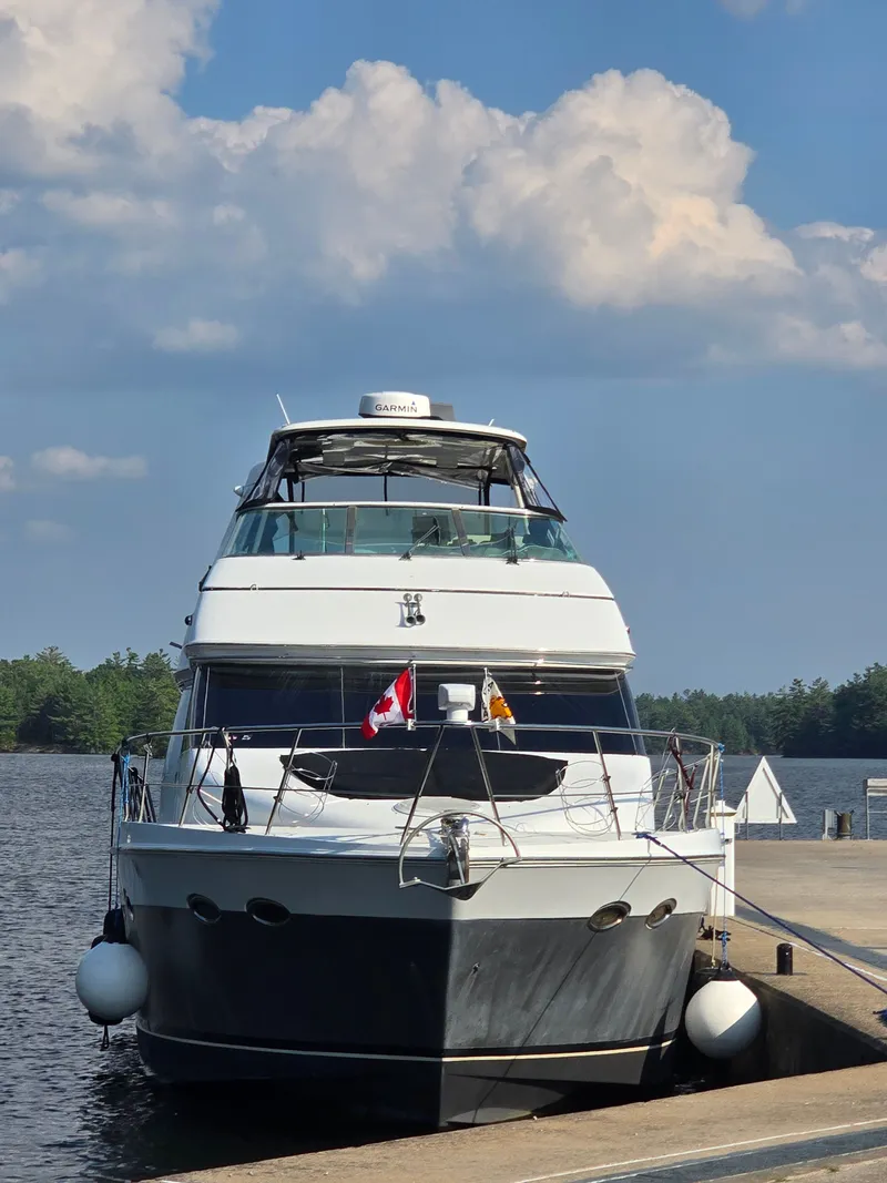 Slide: The Image of A 2002 Carver Voyager Pilothouse 530 docked at a calm pier under a cloudy sky. - 3
