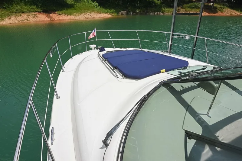 Slide: The Image of 2008 Sea Ray 38 Sundancer yacht on serene green water, featuring a sun pad and railing. - 26