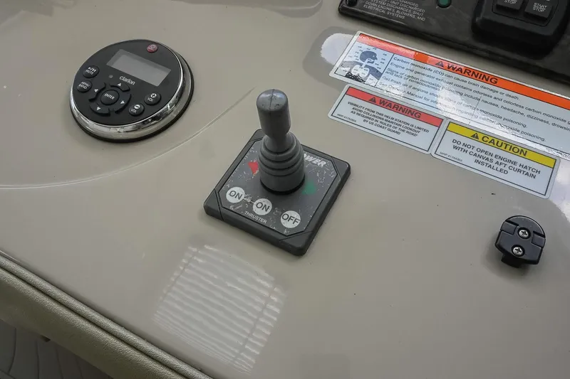 Slide: The Image of Control panel of a 2008 Sea Ray 38 Sundancer boat with joystick and warning labels. - 23