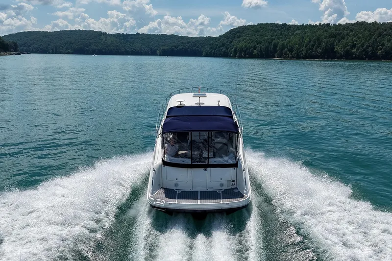 Slide: The Image of 2008 Sea Ray 38 Sundancer cruising on a scenic lake with lush green hills. - 64