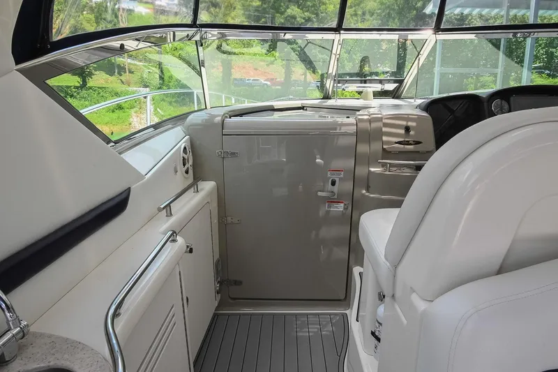Slide: The Image of 2008 Sea Ray 38 Sundancer cockpit with helm, seating, and cabinetry, showcasing luxury yacht interior. - 15