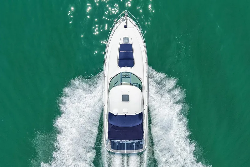 Slide: The Image of Aerial view of a white 2008 Sea Ray 38 Sundancer cruising through turquoise water. - 1