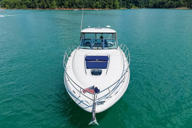 Slide: The Image of 2008 Sea Ray 38 Sundancer yacht cruising on a serene lake with lush green shoreline. - 5