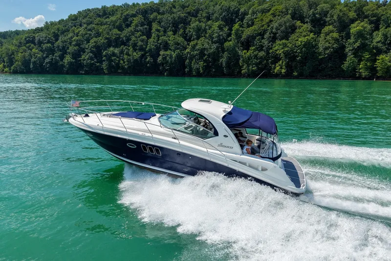 Slide: The Image of 2008 Sea Ray 38 Sundancer cruising on a scenic lake with lush green forest backdrop. - 73