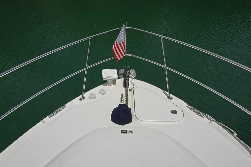 Slide: The Image of Bow view of 2008 Sea Ray 38 Sundancer with American flag on calm water. - 30