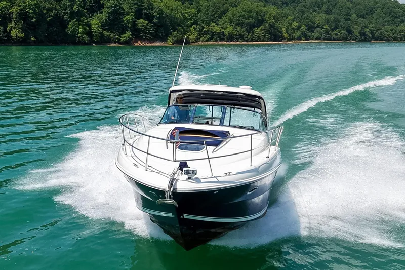 Slide: The Image of A 2008 Sea Ray 38 Sundancer speeds across the water, surrounded by lush green trees. - 74