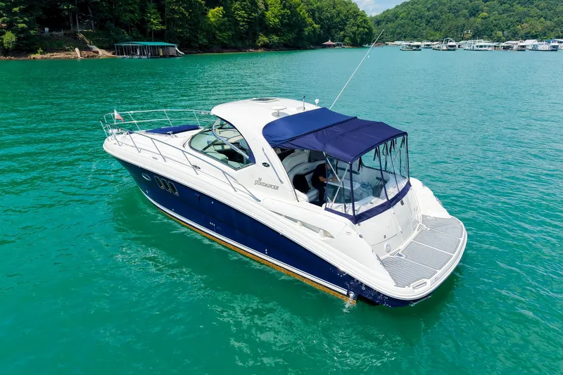 Slide: The Image of 2008 Sea Ray 38 Sundancer yacht on clear turquoise water, surrounded by lush greenery. - 65