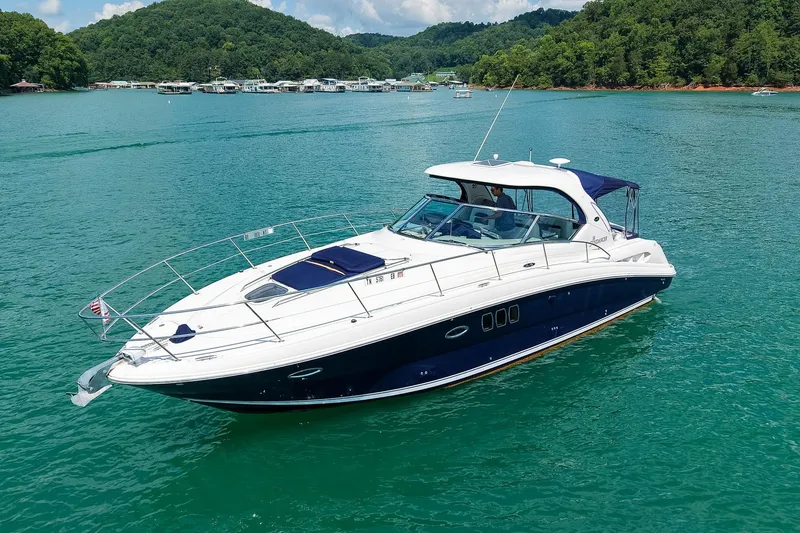 Slide: The Image of 2008 Sea Ray 38 Sundancer yacht cruising on a serene lake with lush green hills. - 69