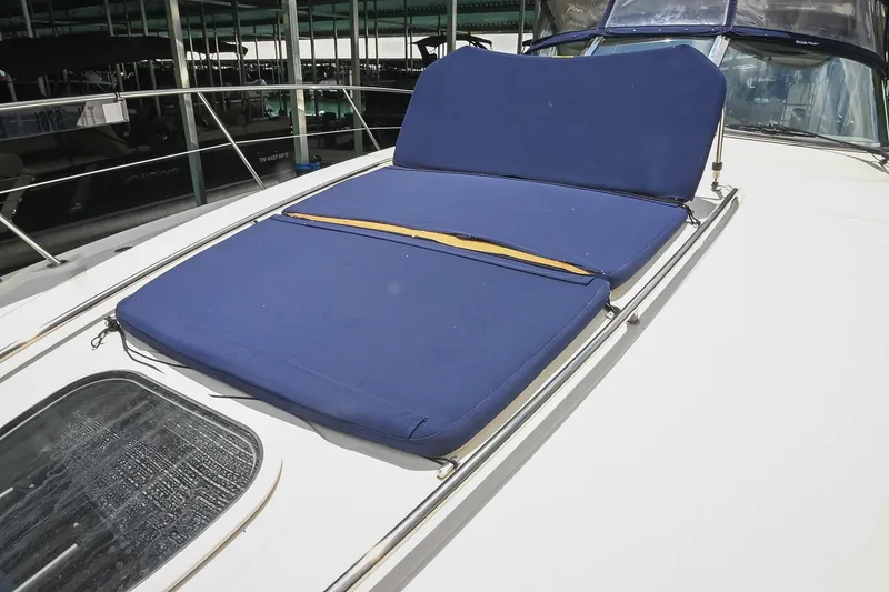 Slide: The Image of 2008 Sea Ray 38 Sundancer with blue sunpad on deck, docked in marina. - 28