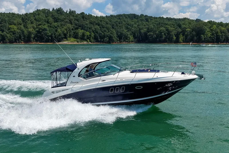 Slide: The Image of 2008 Sea Ray 38 Sundancer cruising on a serene lake with lush green forest backdrop. - 71