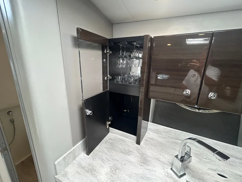 Slide: The Image of The interior of a 2017 Formula 37 Performance Cruiser features a cabinet with glasses and a sink. - 42