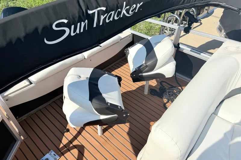 Slide: The Image of 2011 Sun Tracker Fishin' Barge 21 interior with swivel seats and wood-patterned flooring. - 17