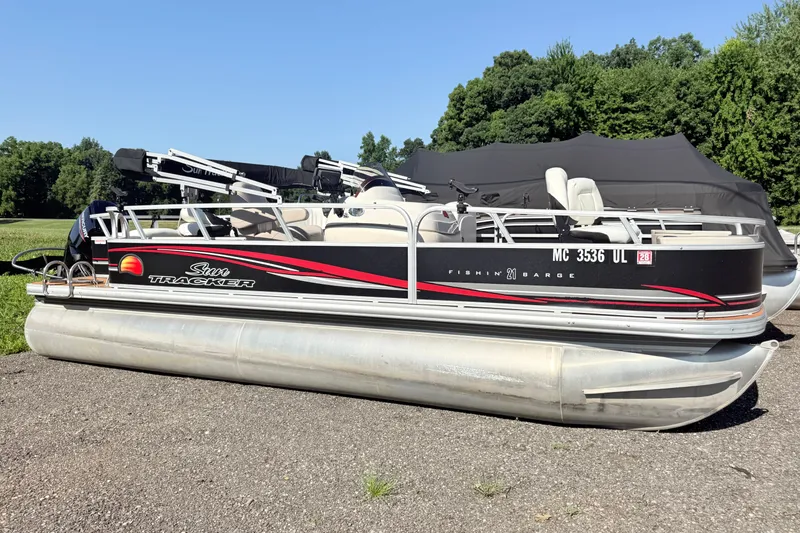 The Image of 2011 Sun Tracker Fishin' Barge 21 pontoon boat parked on gravel with trees in background. - 0