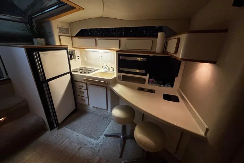 Slide: The Image of 1994 Sea Ray 400 Express Cruiser interior kitchen with stove, sink, and seating area. - 11