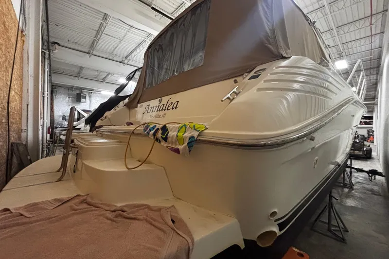 Slide: The Image of 1994 Sea Ray 400 Express Cruiser in storage, rear view with covered deck. - 32