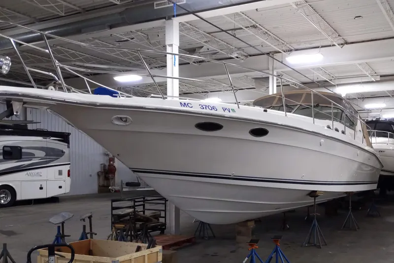 Slide: The Image of 1994 Sea Ray 400 Express Cruiser in indoor storage, showcasing sleek design and white hull. - 33
