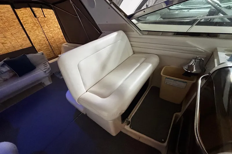 Slide: The Image of Interior of 1994 Sea Ray 400 Express Cruiser with white seating and window view. - 16