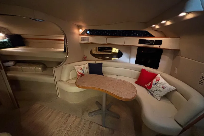 Slide: The Image of Interior of 1994 Sea Ray 400 Express Cruiser with cozy seating and decorative pillows. - 13