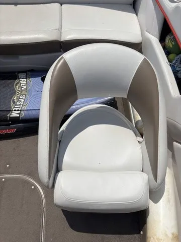 Slide: The Image of A white and gray boat seat in the interior of a boat, surrounded by cushions. - 10