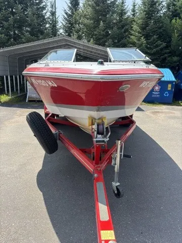 Slide: The Image of A red 2007 Four Winns 200 Horizon boat on a trailer, surrounded by trees. - 3