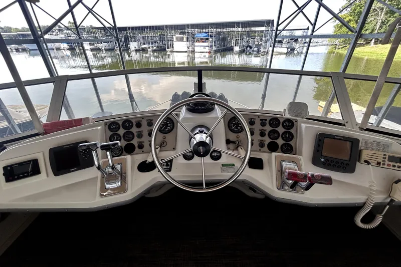 Slide: The Image of 1999 Carver 326 Aft Cabin Motor Yacht helm with steering wheel and control panel. - 7
