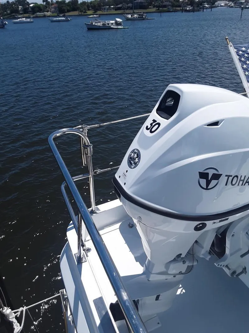 Slide: The Image of 2024 Ultra Lite Tenders Rigged 380 with Tohatsu engine on a sunny waterfront. - 7