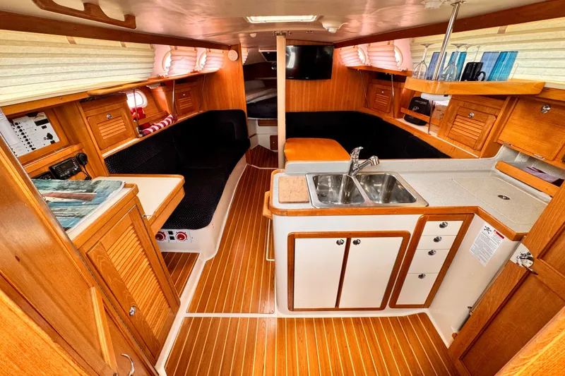 Slide: The Image of Interior of a 2006 Catalina 34 MkII sailboat with wood finish and compact kitchen. - 2