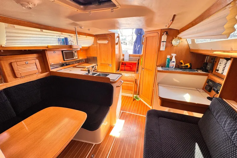 Slide: The Image of Interior of 2006 Catalina 34 MkII sailboat with cozy seating and wooden cabinetry. - 2