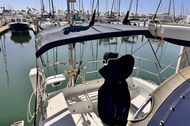 Slide: The Image of 2006 Catalina 34 MkII sailboat docked in marina, featuring covered cockpit and calm waters. - 12