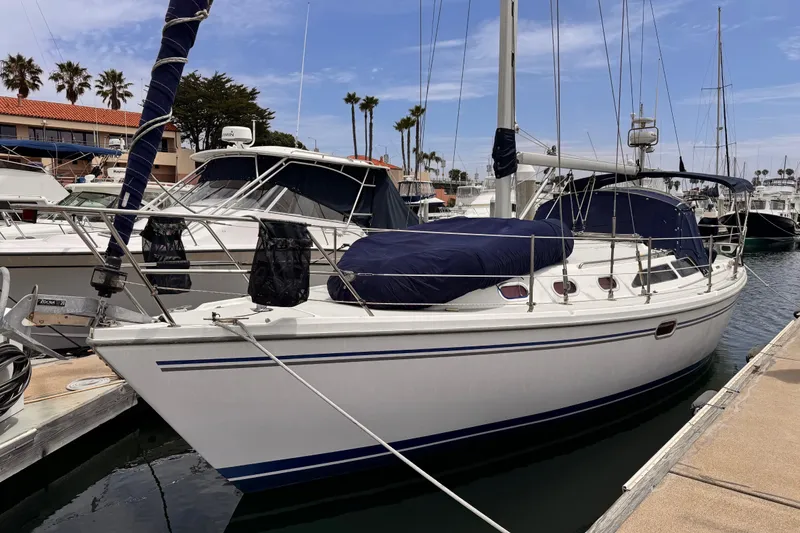 The Image of 2006 Catalina 34 MkII sailboat docked at marina with blue covers and clear sky. - 1