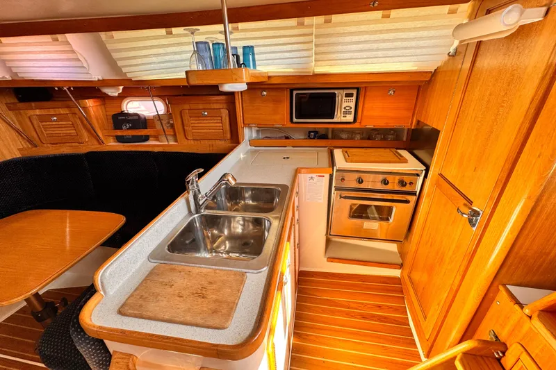 Slide: The Image of Interior of 2006 Catalina 34 MkII sailboat kitchen with wood cabinetry and modern appliances. - 3