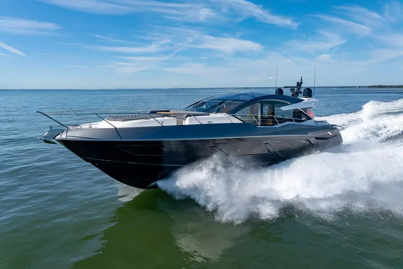 Slide: The Image of 2020 Sunseeker Predator 74 yacht cruising on open water under a clear blue sky. - 25