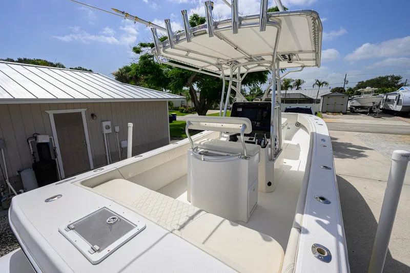 Slide: The Image of 2007 Competition 25 boat with T-top, docked near a building under a clear sky. - 24