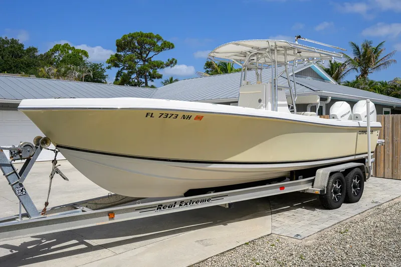 Slide: The Image of 2007 Competition 25 boat on trailer, parked outdoors under clear blue sky. - 10