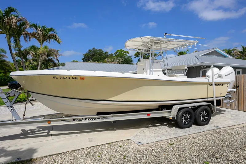 Slide: The Image of 2007 Competition 25 boat on trailer, parked outdoors under clear blue sky. - 11