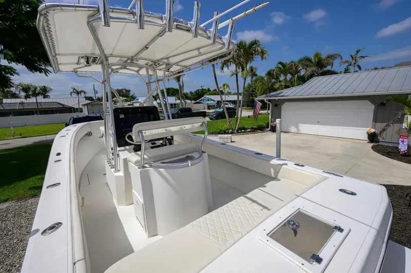 Slide: The Image of 2007 Competition 25 boat with T-top, parked in driveway, surrounded by palm trees. - 25