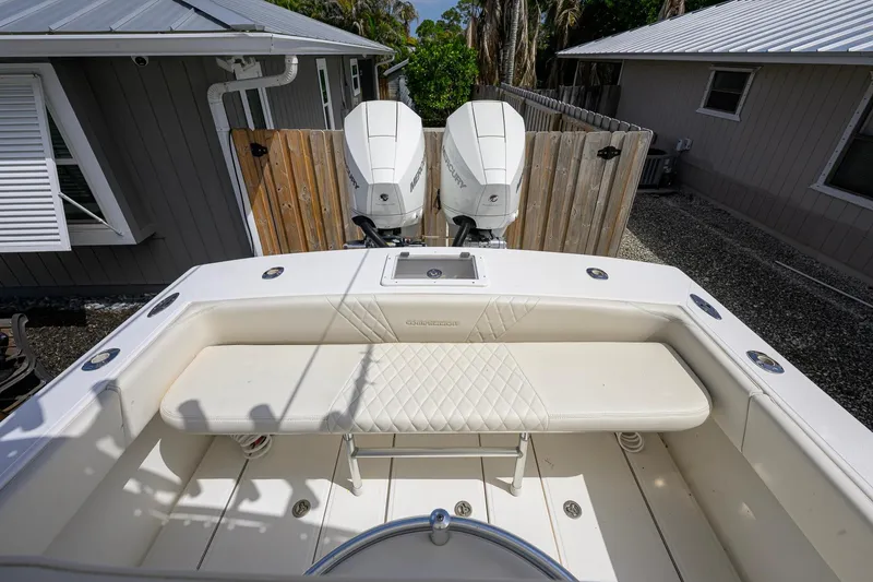 Slide: The Image of 2007 Competition 25 boat with dual Mercury engines, docked near wooden fence. - 4