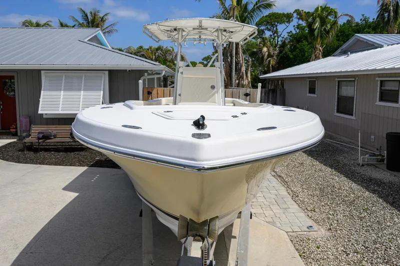 Slide: The Image of 2007 Competition 25 boat on trailer in residential driveway, surrounded by houses and palm trees. - 14