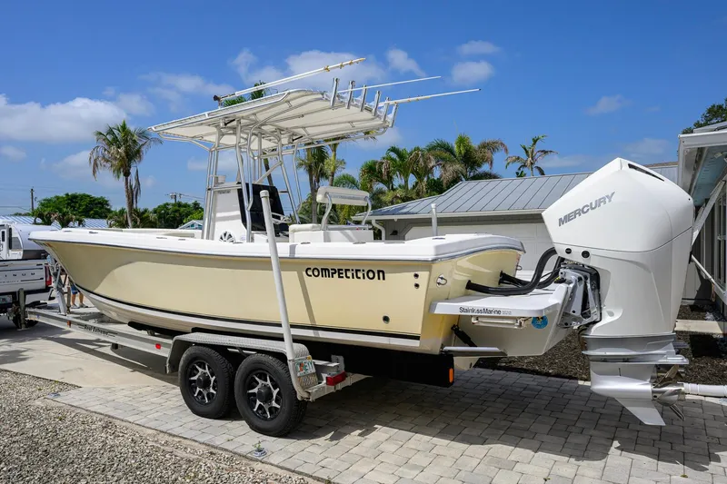 Slide: The Image of 2007 Competition 25 boat on trailer with Mercury engine, parked outdoors under blue sky. - 13