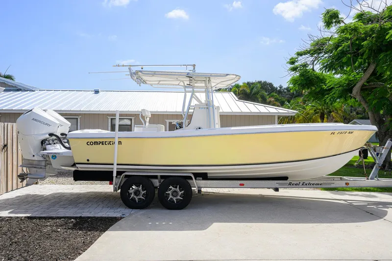 Slide: The Image of 2007 Competition 25 boat on trailer, parked in driveway, with Mercury outboard engine. - 8