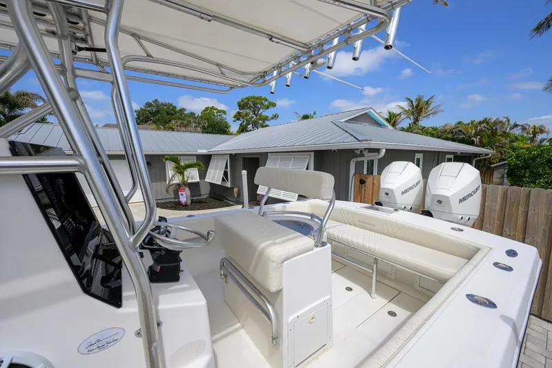 Slide: The Image of 2007 Competition 25 boat with dual Mercury engines, parked near a house with a metal roof. - 26