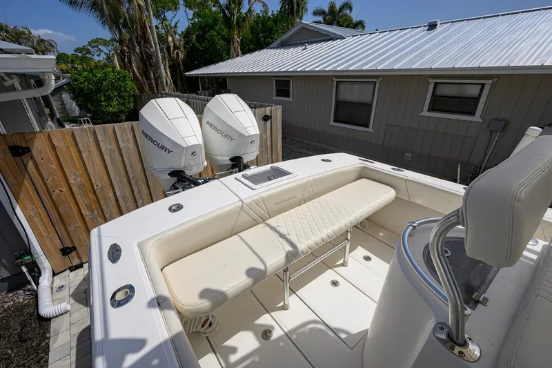 Slide: The Image of 2007 Competition 25 boat with dual Mercury engines, parked near a wooden fence. - 28