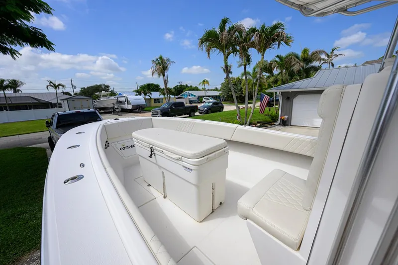 Slide: The Image of 2007 Competition 25 boat with seating and cooler, parked near palm trees and vehicles. - 17